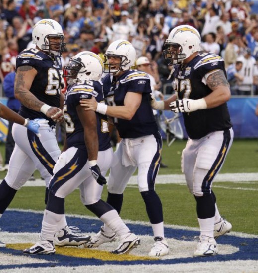 San Diego Chargers' Mike Tolbert. second from left, is surrounded by teammates Louis Vasquez, left, Billy Volek, and Brandyn Dombrowski, right, after scoring the go-ahead touchdown with 39 seconds left in the Chargers' 23-20 victory over the Washingt
