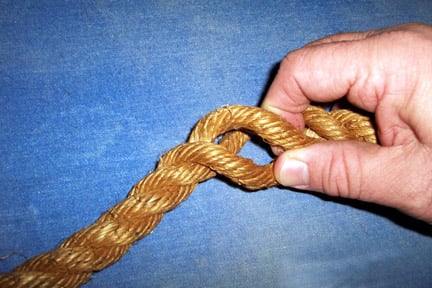 Grasp the rope at the point where you want the end to attach to the shaft of the rope.