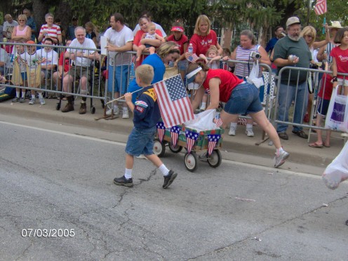 A little boy marching with the US Flag