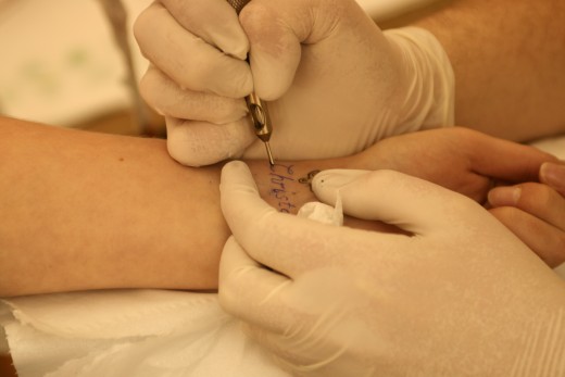 A woman getting tattoo lettering - a common tattoo motive.