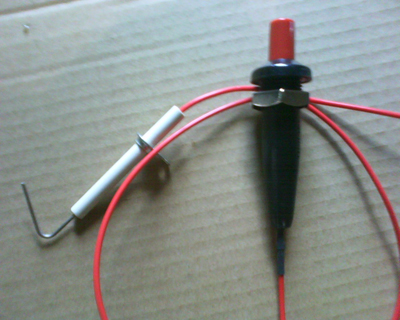 Older-style barbeque grill igniter piezo.  Every click of the red button creates one spark at the electrode to light the gas grill.