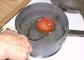 Make it easy on yourself, and hold the tomato in the boiling water for 20 seconds with a large pair of tongs.