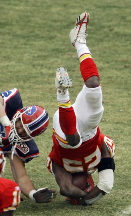Kansas City Chiefs running back Jamaal Charles, right, is upended by Buffalo Bills defensive end Ryan Denney, left, during the second quarter of an NFL football game Sunday, Dec. 13, 2009, in Kansas City, Mo. (AP Photo/Charlie Riedel)