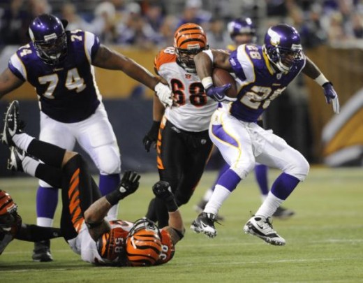 Minnesota Vikings' Adrian Peterson runs past Cincinnati Bengals' Rey Maualuga (58) during the first half of an NFL football game Sunday, Dec. 13, 2009, in Minneapolis. (AP Photo/Hannah Foslien)