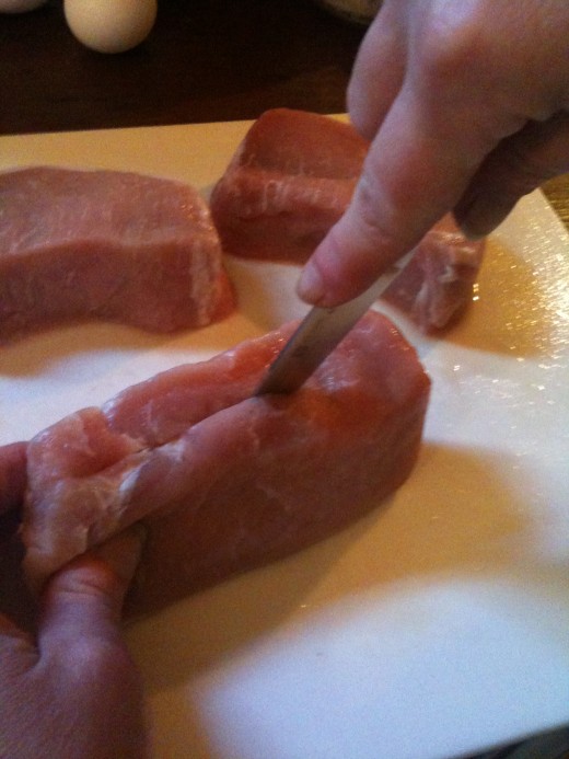Holding the chop on its side, carefully slice into the other side with a paring knife. Don't cut all the way through!
