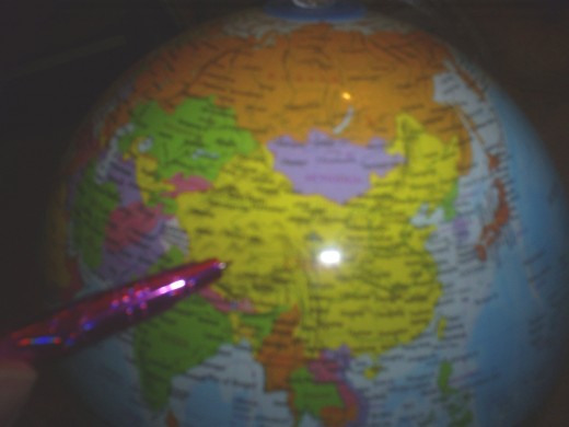 Pointing to China on the globe.
