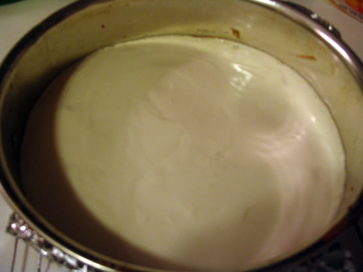 Smooth the sour cream on top of the cheesecake.