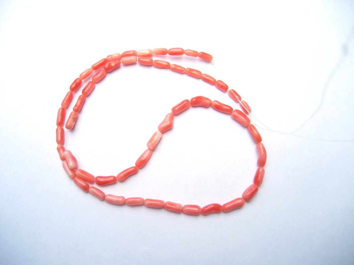 Salmon pink coral rice shaped beads that are high quality with brilliant color and polish. 