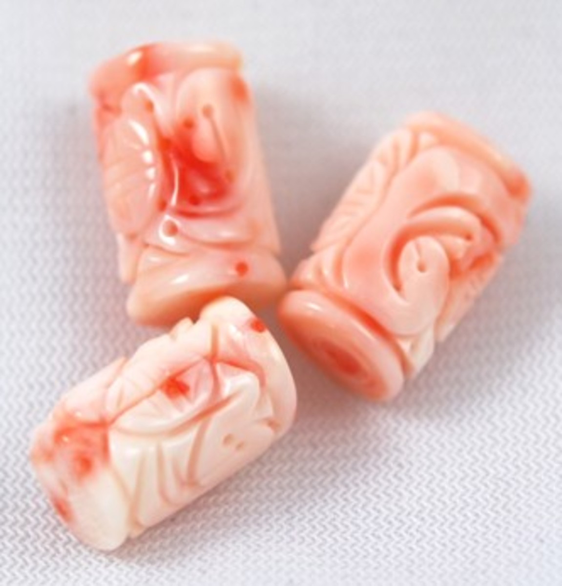 Natural angel skin coral pendant bead that has been hand carved in a lovely floral pattern on both sides. It has been drilled vertically.  