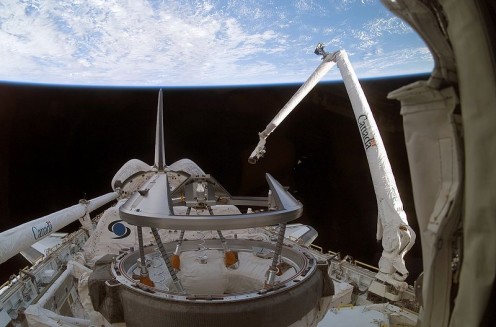 2006 -- The Canadarm aiding the US Space Shuttle Discovery during mission STS-116. 