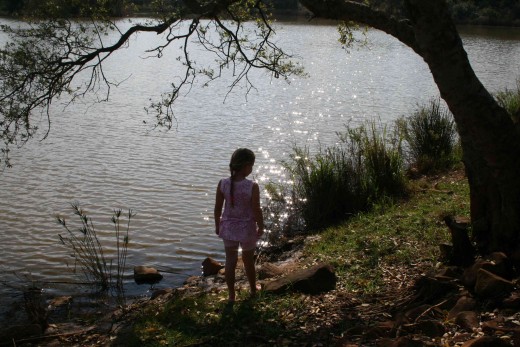 Sun glinting off the quiet water while my daughter Caitlin explores