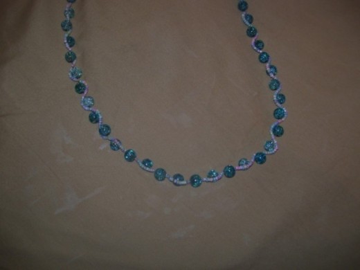 Ocean Waves-This beautiful piece is made with glass seed beads, crinkle glass beads, gold tone nylon coated wire, gold tone crimp beads, and a gold tone clasp. 
