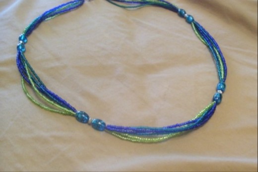 Grace, Calm, and Summer Fun- This necklace is a fun one with glass beads in blues and blue greens, silver bi-cone beads, and seed beads in dark blue, blue green, and lime. 