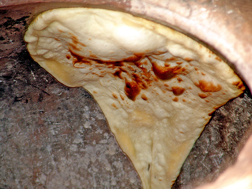 Naan/Indian Bread being cooked in a tandoor