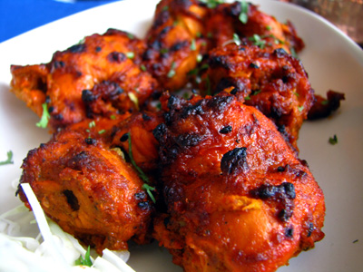 Whole Tandoori chicken cooked in the Tandoor and cut into pieces for serving.
