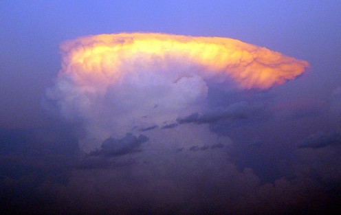 The setting sun lights up the anvil portion of a thunderstorm.