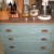 Old bureau with marble top serves as counter space and storage for pans