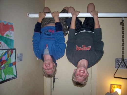 My boys hanging upside down like bats on a pole in my parent's room. The pole extends over my parents' bed and has one or two other items hanging down from it (besides my children) that my father uses to excercise.