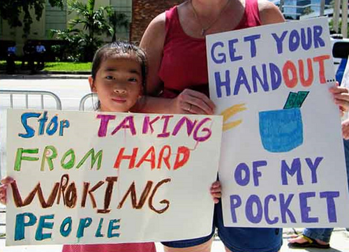 It is funny because with signs like these. I know the rich are thinking the same thing about the people holding these signs. Give me your money, get your hands out of our pocket. Give us your money peasants, and shut up already!