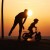 Dad pushing son on bicycle at the beach   Courtesy of www.Photo8.com