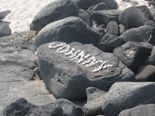 Traveling around the island one frequently encounters "lava graffitti" - words or designs created by arranging white coral stones to make words or designs on the jet black rocks or sheets of hardened lava.  The white on black stands out but no damage