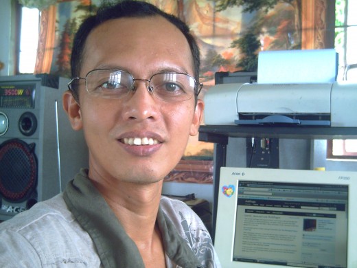 Travel Man posing beside his desktop computer, celebrating his 1 year of hubbing @ HubPages (Photo by Ireno A. Alcala)