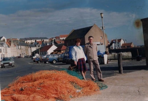 Nets waiting to be repaired while visitors admire the old harbour