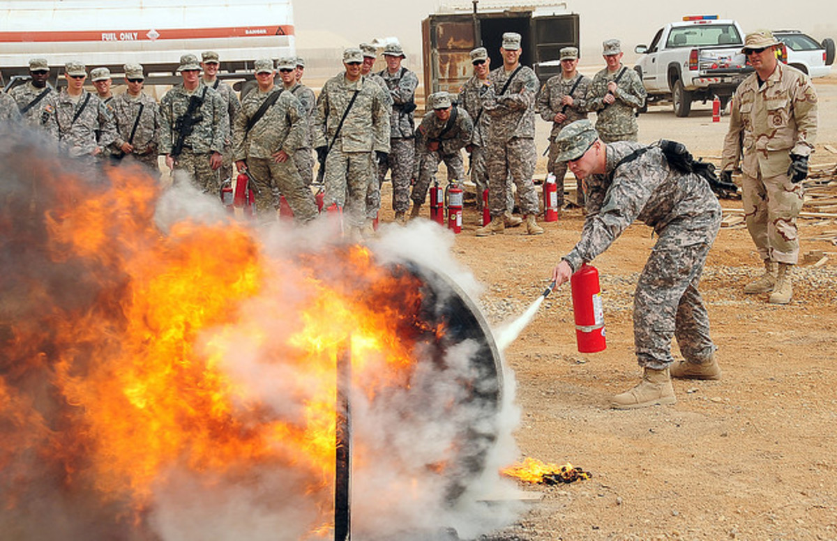 A soldier extinguishing a class A fire.