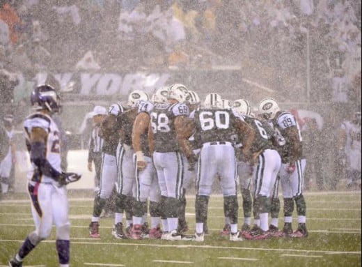 The New York Jets huddle in a driving rain during the second quarter of an NFL football game against the Minnesota Vikings on Monday, Oct. 11, 2010, in East Rutherford, N.J. (AP Photo/Bill Kostroun)