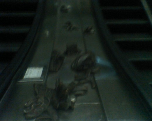 Bronzed gloves on an escalator