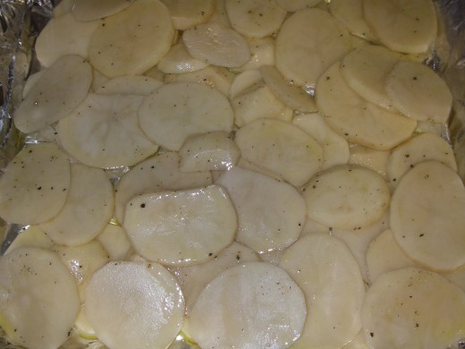 Bring pot of salted water to the boil. Thinly slice the potatoes and blanch them in the boiling water for 1 minute. Drain, and then arrange the slices over a baking tray. Place chips in oven and cook for 20 minutes till golden brown.
