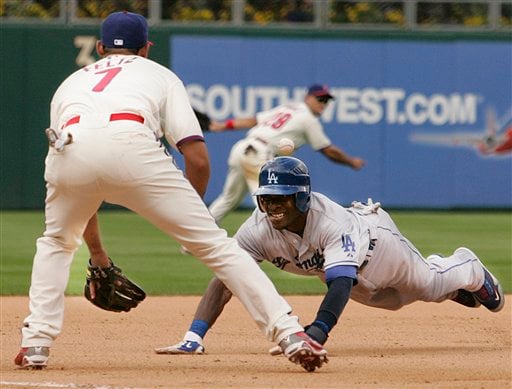 The Dodgers' Orlando Hudson, right, dives for third base ahead of the throw from the outfield to Philadelphia Phillies third baseman Pedro Feliz, left, in the eighth inning of a baseball game Thursday, May 14, 2009, in Philadelphia. The Dodgers won 5