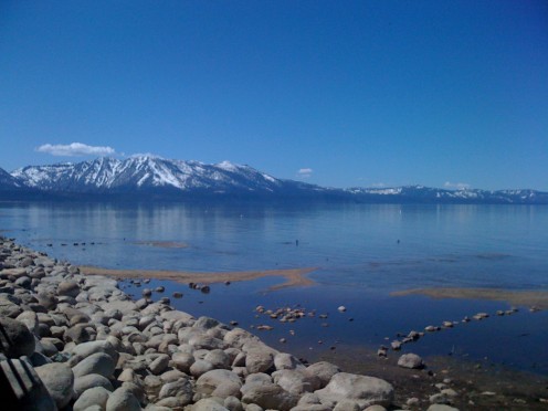 One of Tahoe's beautiful beaches with snow-capped mountains in the background.