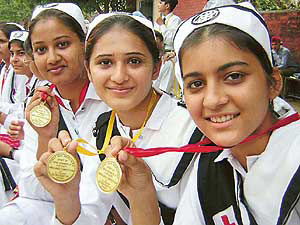 Indian girl students showing off their medals of academic excellence.