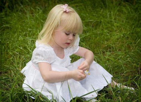 Grandness of the world shown in a little blond girl in a white dress and pink bow