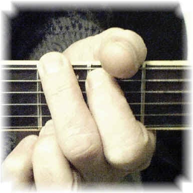 G chord being fingered on the guitar