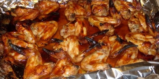 Chicken wings in pan lined with foil.  Foil keeps the wings from sticking to the pan and making a huge mess.