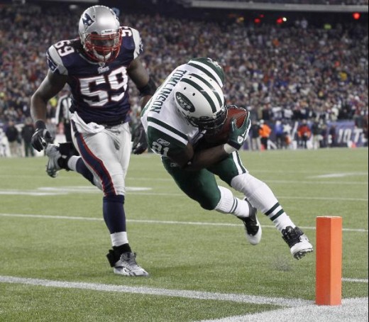 New York Jets running back LaDainian Tomlinson (21) scores a touchdown in front of New England Patriots linebacker Gary Guyton (59) during the first half of an NFL divisional playoff football game in Foxborough, Mass., Sunday, Jan. 16, 2011. (AP Phot