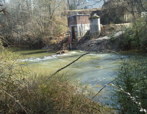 The small set of rapids on the Lulawissie River near the pumping station. The fish will be laying just this side of the white water, waiting for food, and also in the shaded area beneath and to the right of the building.