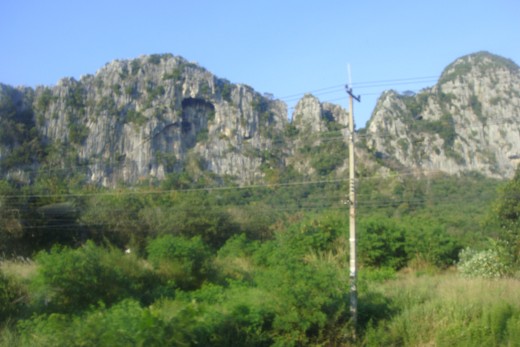 This rock mountain has a cave like cut out. 