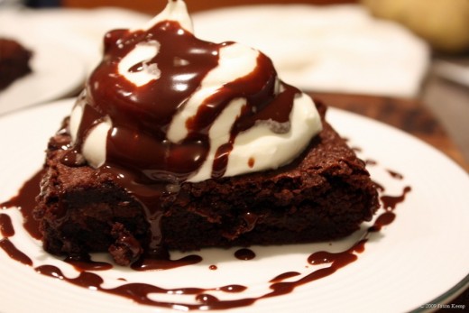 Brownie with fresh cream and chocolate drizzle. 
