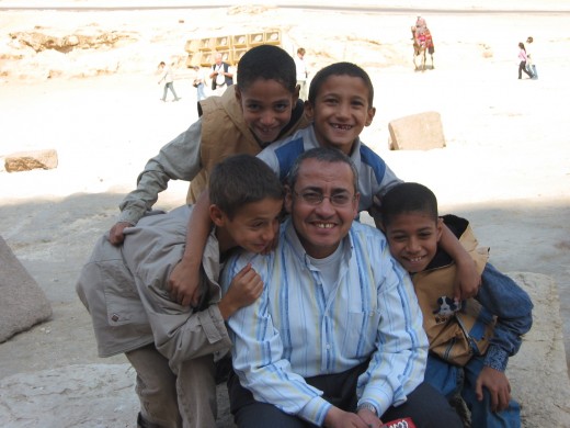 A  friendly Cairo school teacher with lively students playing near the pyramids.