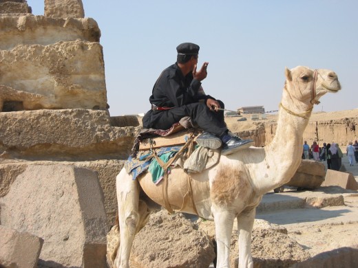 An Egyptian policeman smokes a cigarette while guarding the pyramids reached on a short bus ride to Cairo's outskirts.