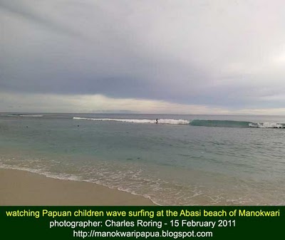 photo of Papuan children wave surfing taken with my cell phone camera that does not have optical zoom device