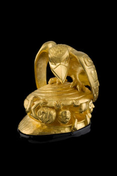 Raven encourages the first men to creep out of the clamshell. Small golden sculpture.