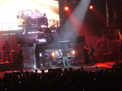 Toby getting out from the back of his pickup cab on stage, singing and strumming for his fans!