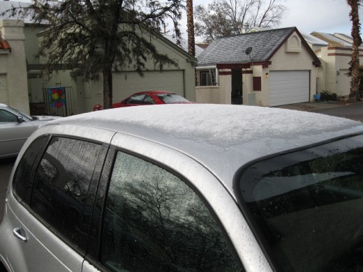 Snow on roofs of homes and cars