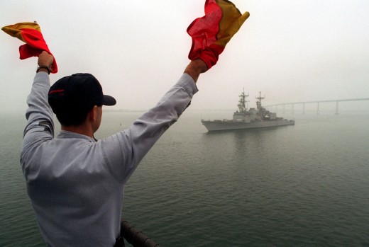 Navy Signalman communicates to oncoming ship