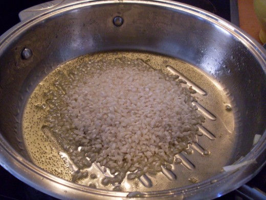 Fry the dry, uncooked rice in the oil till the grains turn pearly white. If you like your vegetables crisp, remove them first. If not, leave them in through the whole cooking process.