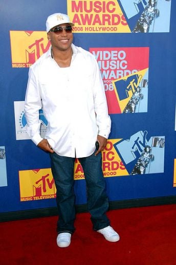 Solid white long sleeved shirt with dark jeans, a chain and solid white sneakers.   Classy but still LL Cool J 'gangster'.